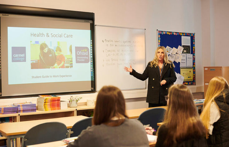 Lecturer teaching students using a projector and screen