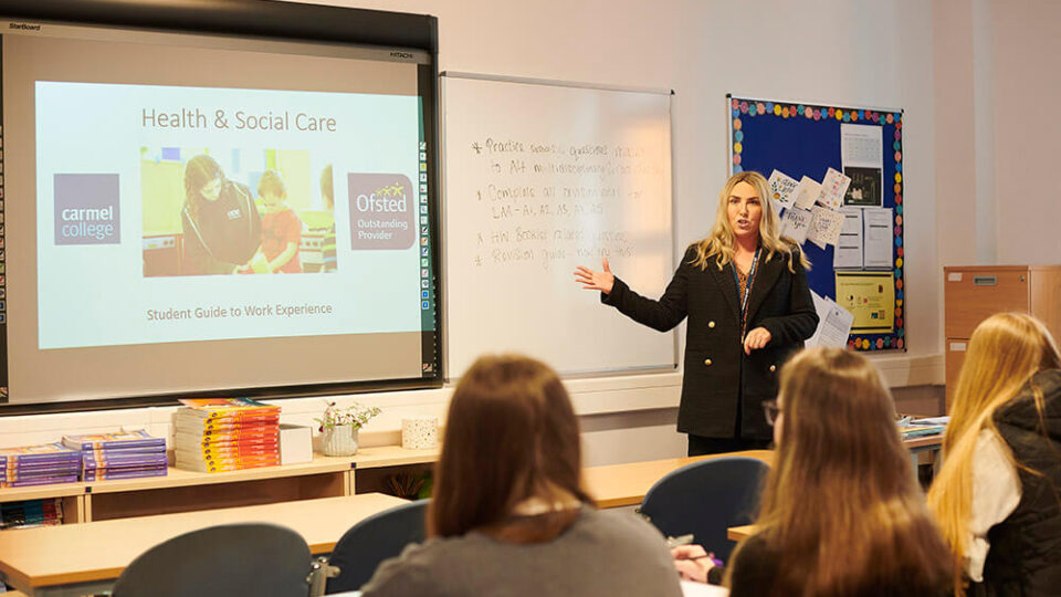 Lecturer teaching students using a projector and screen