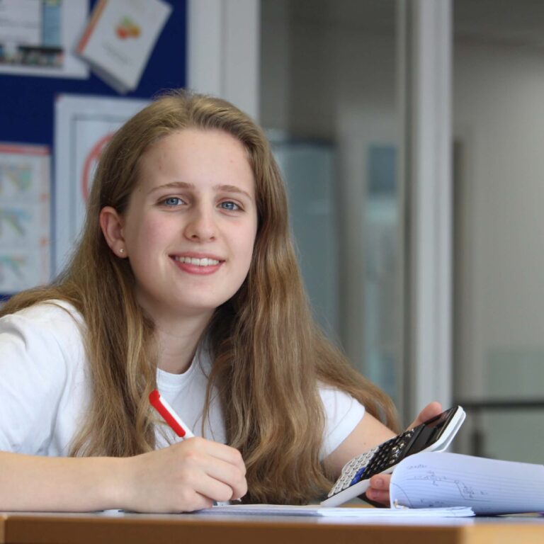 Student sitting at a desk with calculator