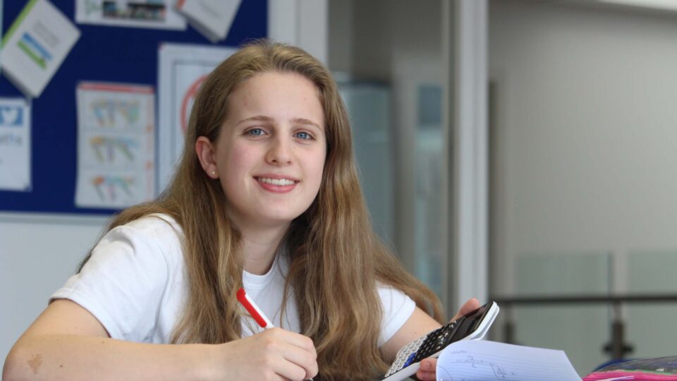 Student sitting at a desk with calculator