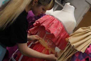 Student on a textiles course and dresses on dummies